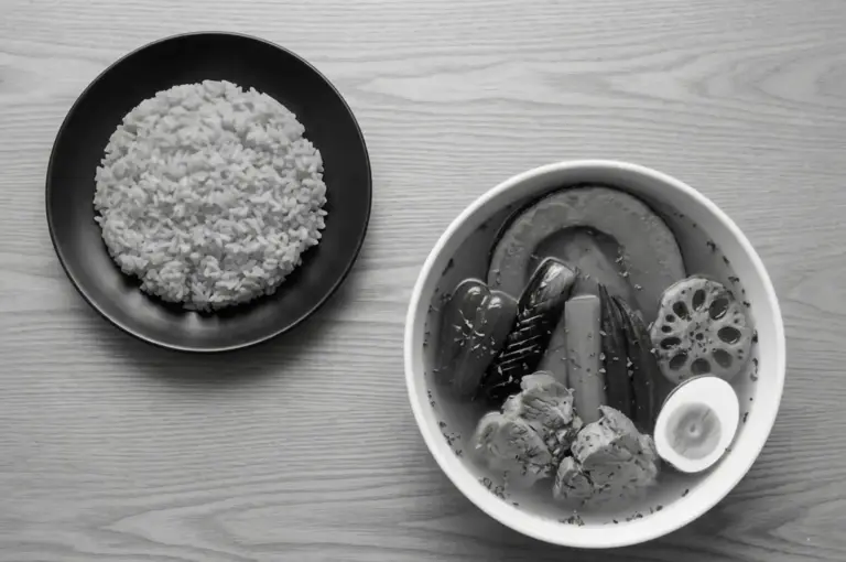 Overhead view of Sapporo-style soup curry featuring lotus root, egg, pumpkin, and meat with separate rice plate