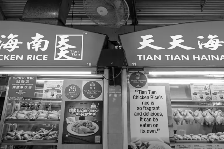 Tian Tian Hainanese Chicken Rice storefront signage at Maxwell Food Centre showing stall numbers 10 and 11 with awards and whole chickens displayed