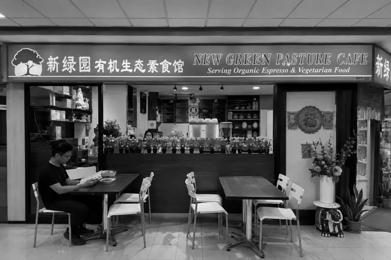 New Green Pasture Cafe storefront with flower display at counter and customer dining at table