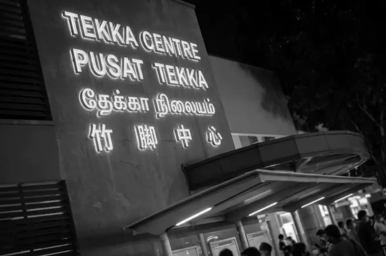 Black and white night view of the illuminated Tekka Centre sign written in English, Malay, Tamil, and Chinese