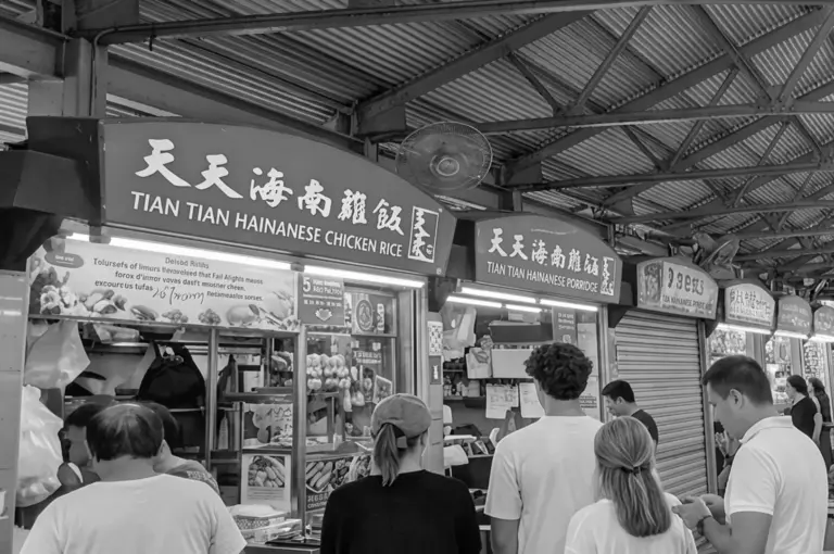 Tian Tian Hainanese Chicken Rice storefront at Maxwell Food Centre with customers queuing and bilingual signage visible