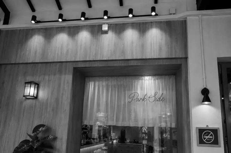 Park Side cafe storefront with wooden paneling, sheer curtain with script lettering, and track lighting