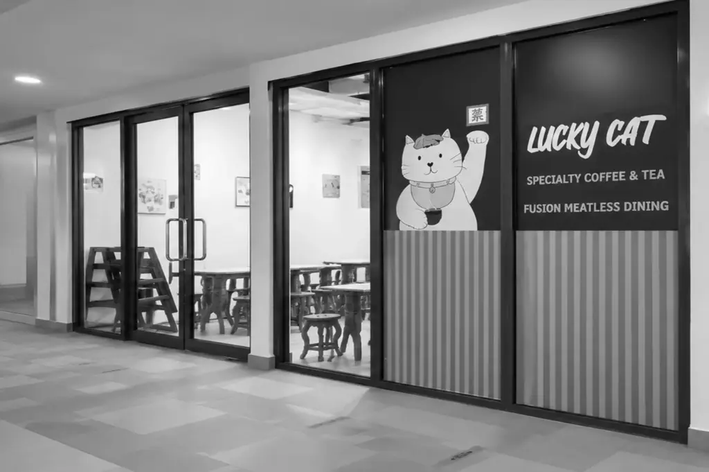 Exterior of Lucky Cat Cafe inside Hougang Community Club with vegetarian dining signage