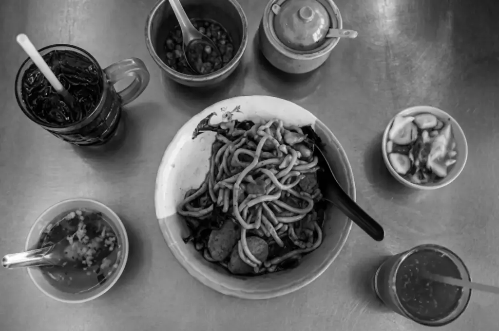 Overhead shot of noodles and sides at a Singapore hawker centre