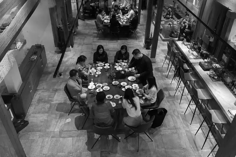Guests enjoying a Korean barbecue dining experience in a modern rustic restaurant