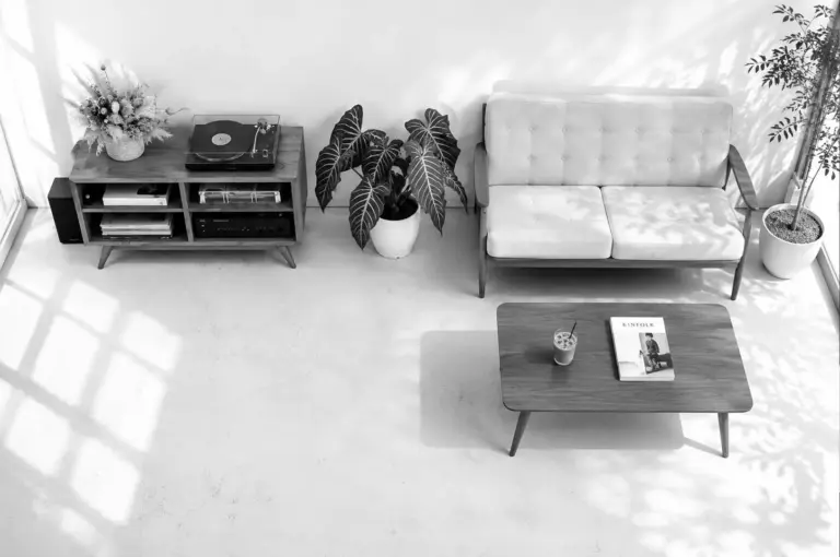 High-angle view of a cozy minimalist seating area with a sofa, record player, and Kinfolk magazine