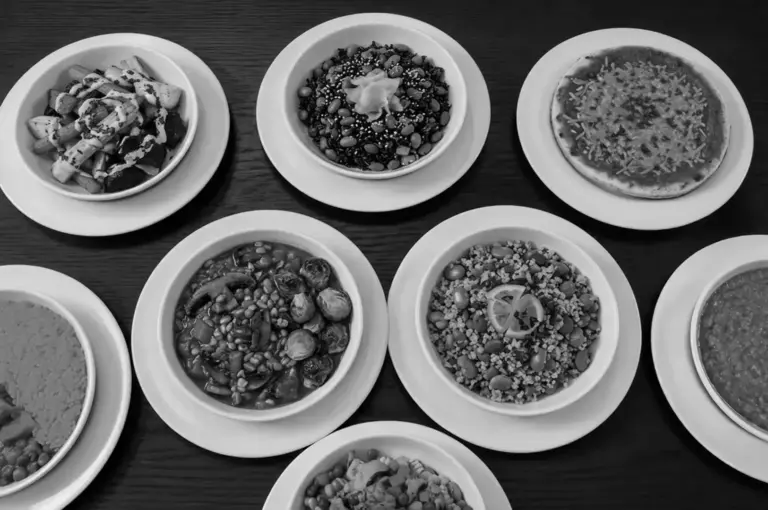 Overhead view of multiple bowls filled with grains and vegetables