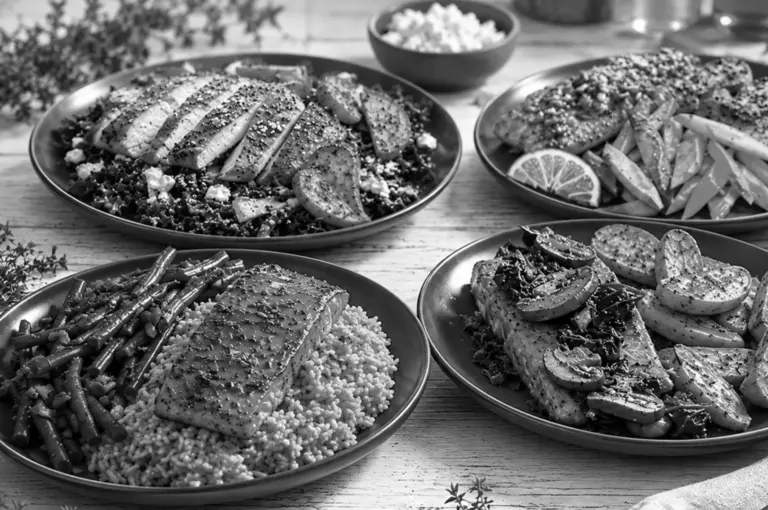 Four plates of fish served with healthy sides like vegetables and grains