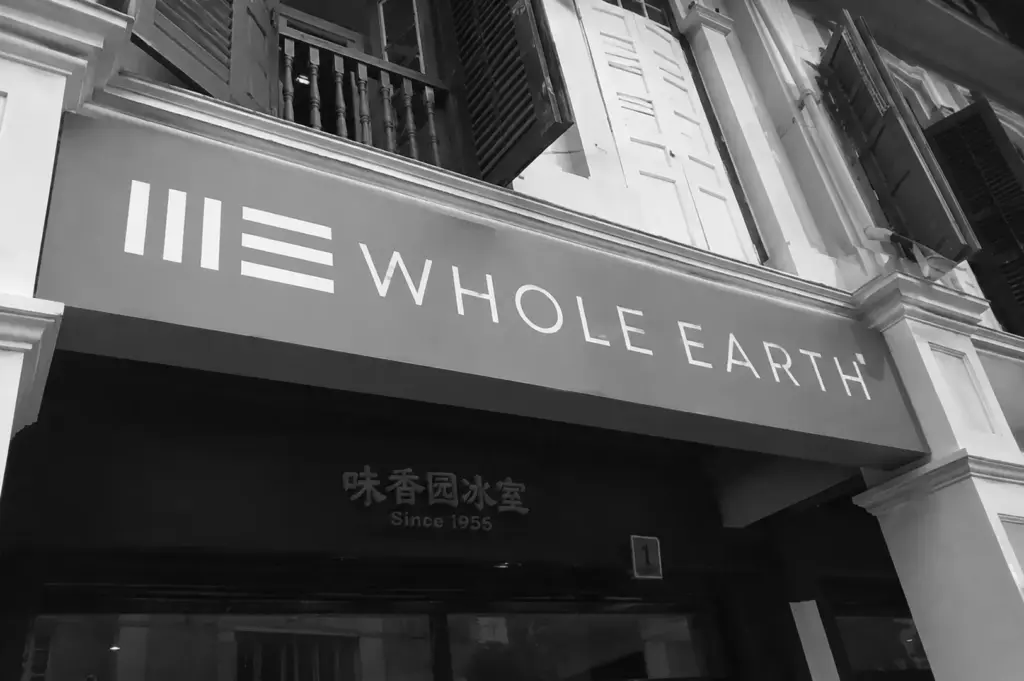 Whole Earth Singapore vegetarian restaurant entrance with modern storefront signage.