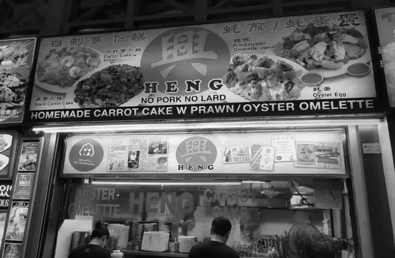 Heng hawker stall at Newton Food Centre with signage advertising homemade carrot cake, oyster omelette, and other signature dishes.