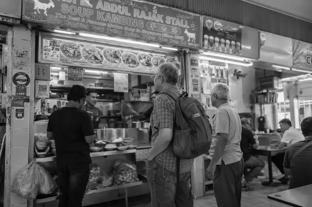 Customers waiting to order at a popular mutton soup stall inside a bustling hawker centre