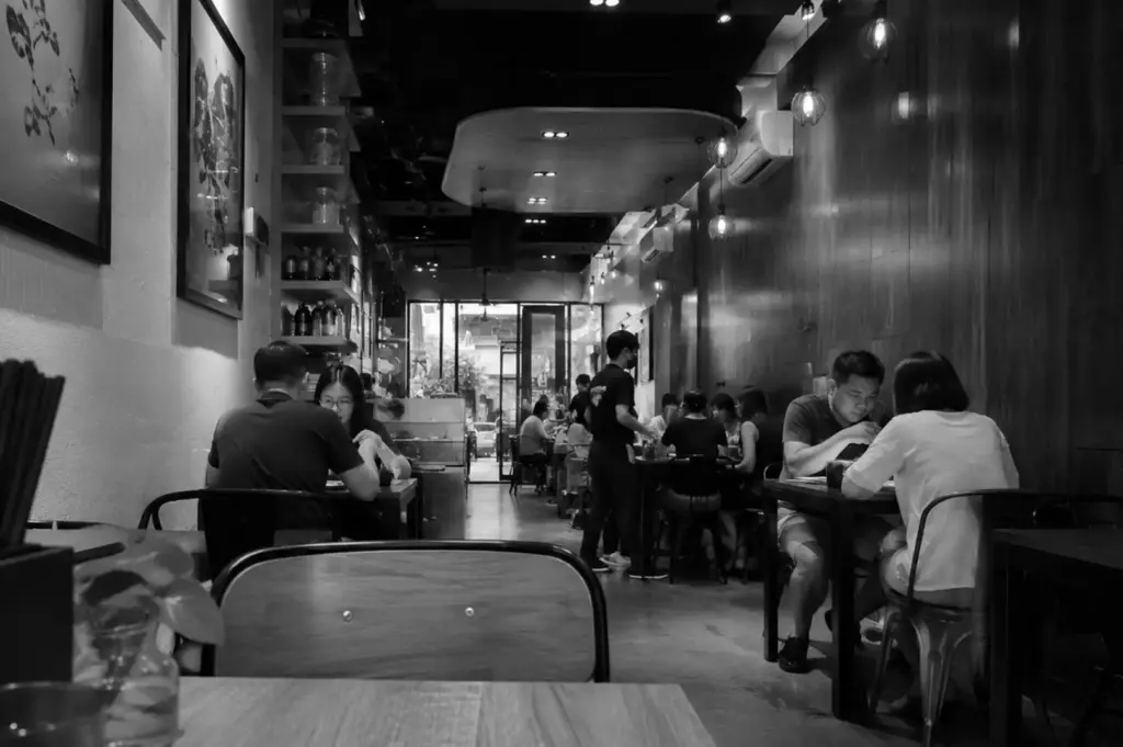 Busy Singapore brunch café with diners seated in a narrow, modern restaurant interior