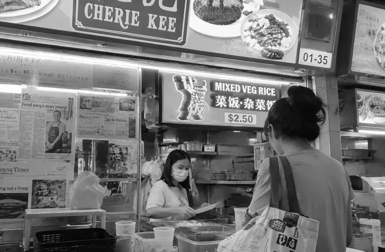 Customer ordering mixed rice at a Singapore hawker food stall.