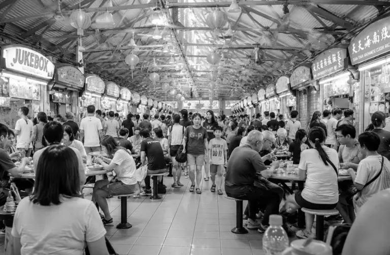 Crowded dining area inside Maxwell Food Centre with popular food stalls.