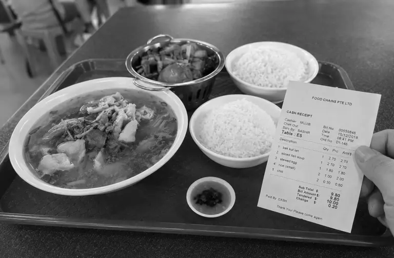 Hawker centre meal with soup, rice, side dishes, and receipt on a tray.