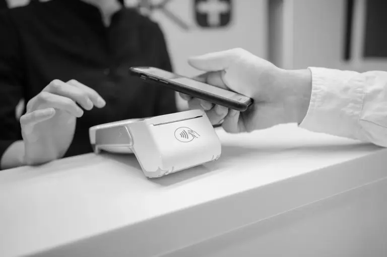 Card payment terminal resting on paperwork at a retail checkout counter.