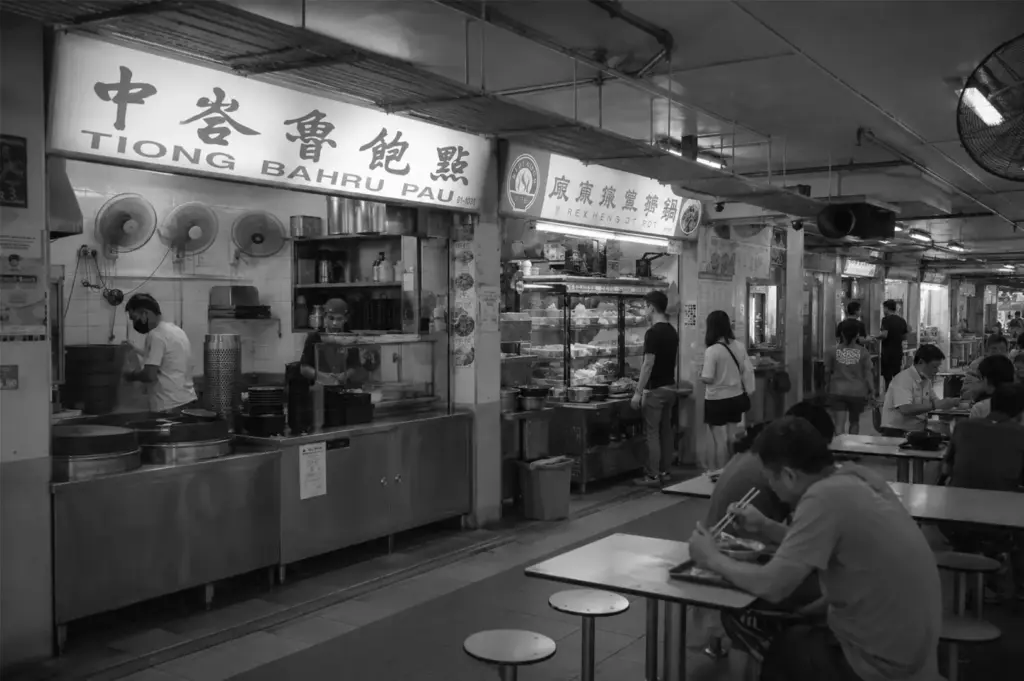 Interior of a busy Singapore hawker centre with popular food stalls and diners enjoying affordable local meals, highlighting the everyday dining culture.