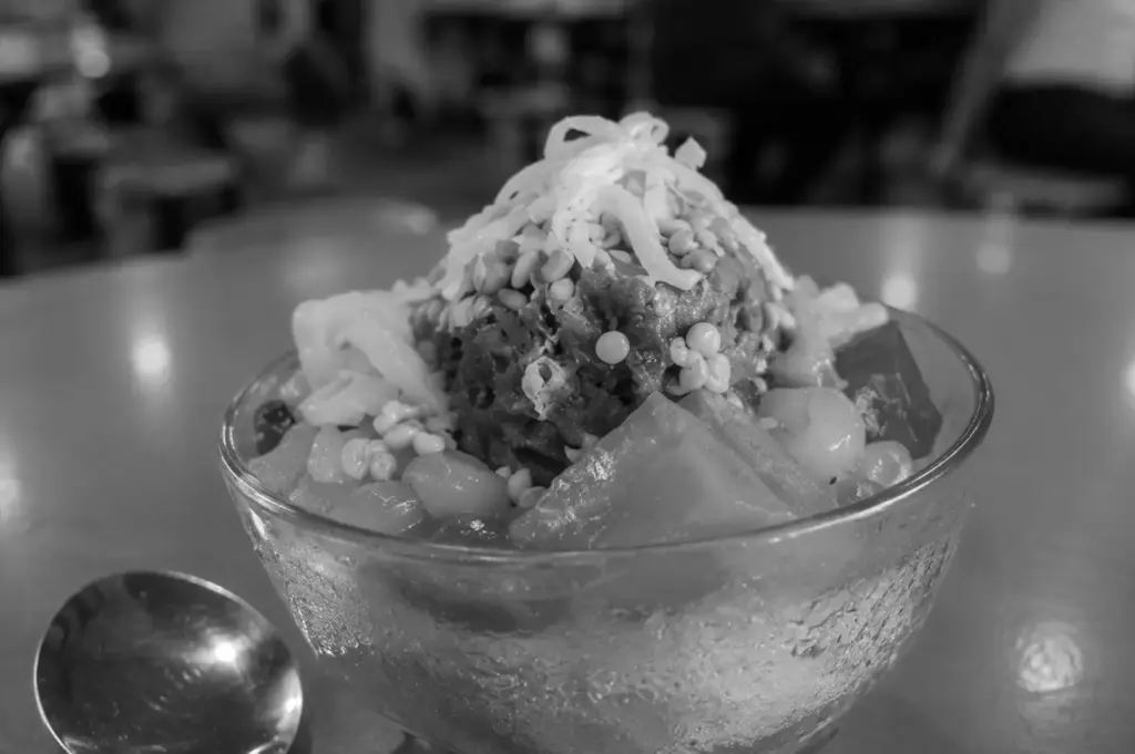 A traditional bowl of colourful shaved ice dessert, capturing the simple joy of cooling off at a neighbourhood hawker centre.