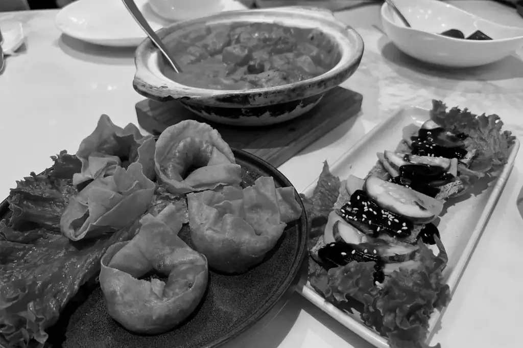 Assorted dim sum, braised claypot dish, and chicken bites served at a Chinese restaurant.