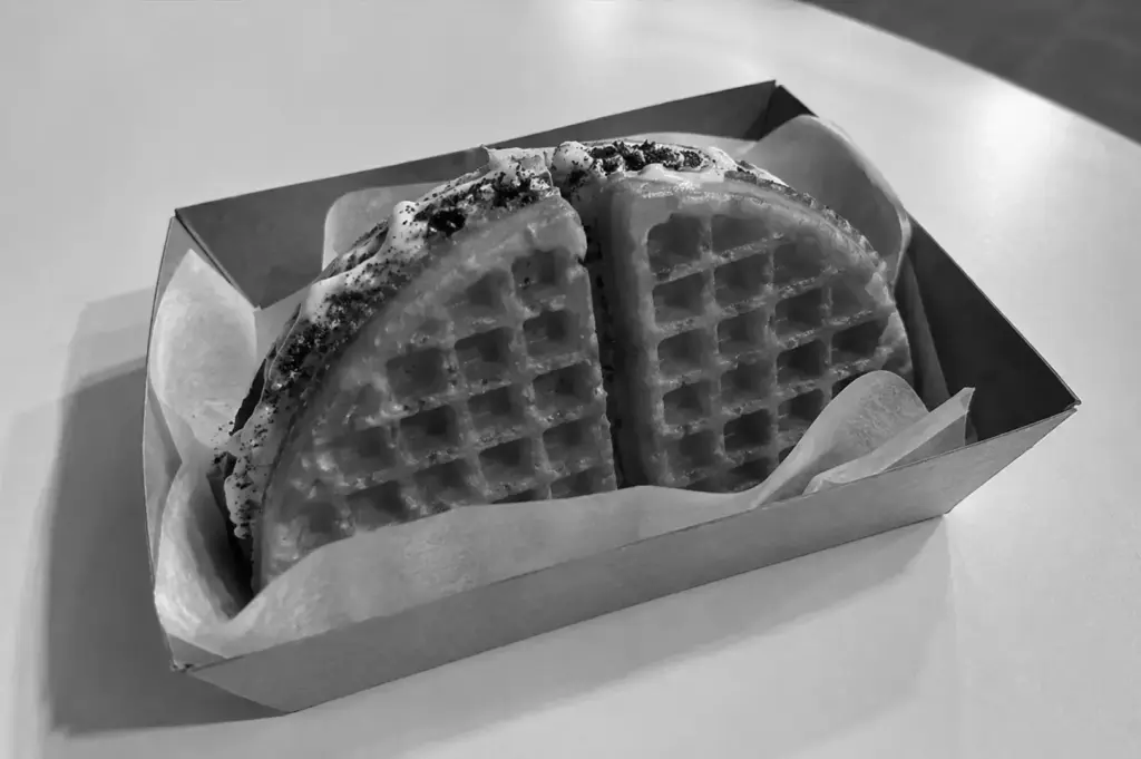 Cookies and cream waffle sandwich served in a takeaway tray.