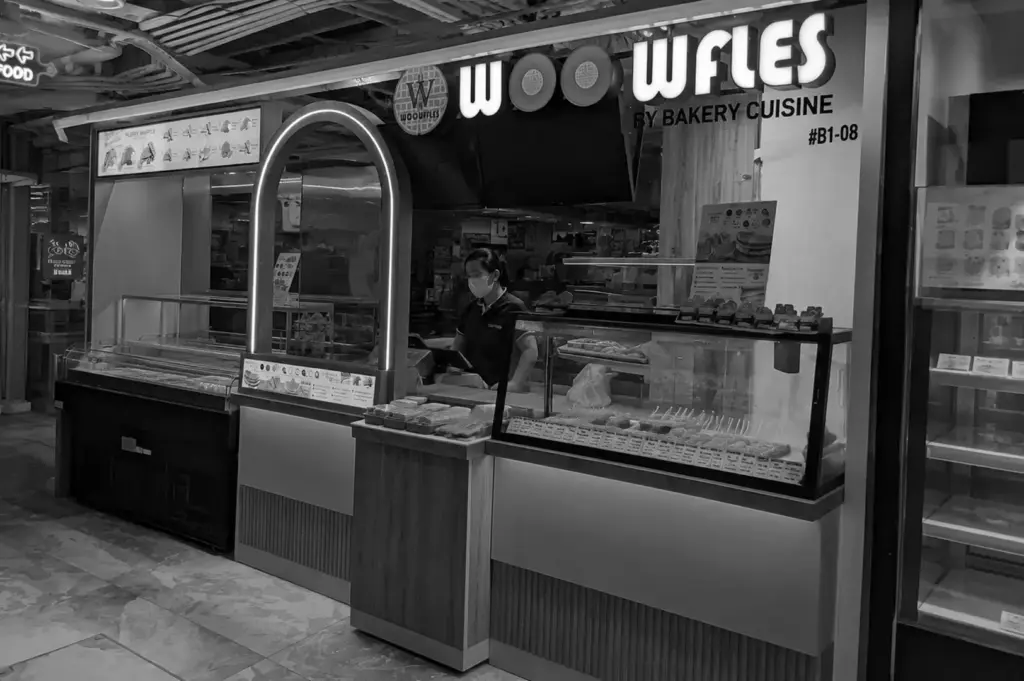 Wooffles dessert kiosk serving freshly made waffles in a shopping mall.