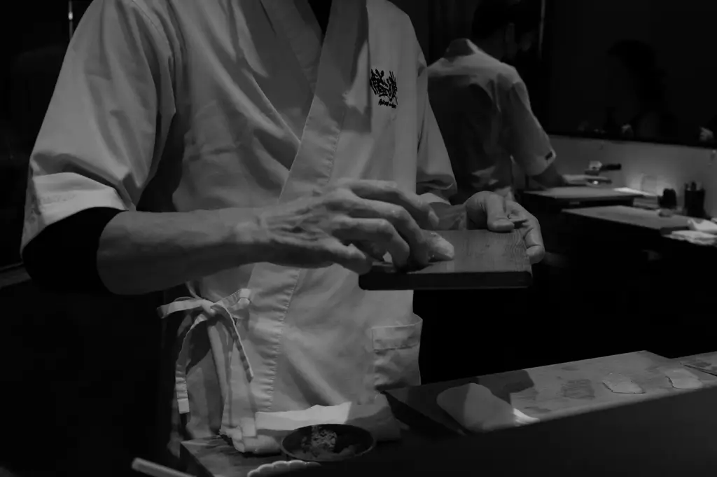 Sushi chef preparing fresh nigiri at a traditional sushi counter
