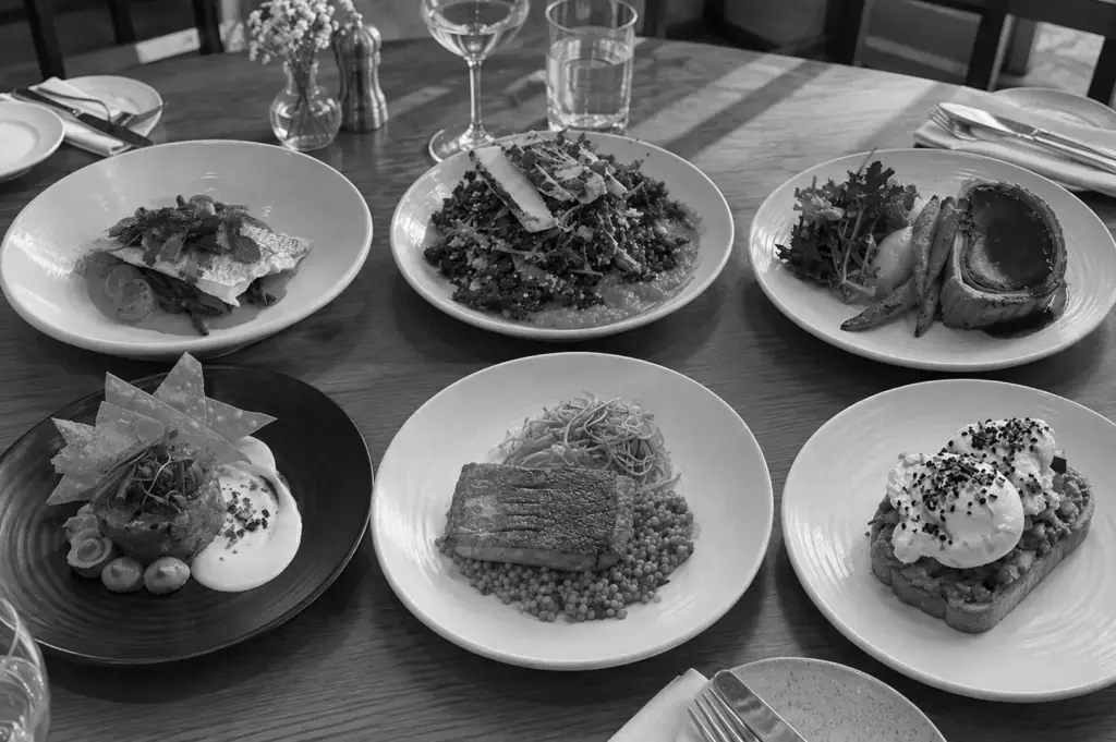 A table filled with assorted dishes and shared plates, highlighting a generous and varied dining spread.