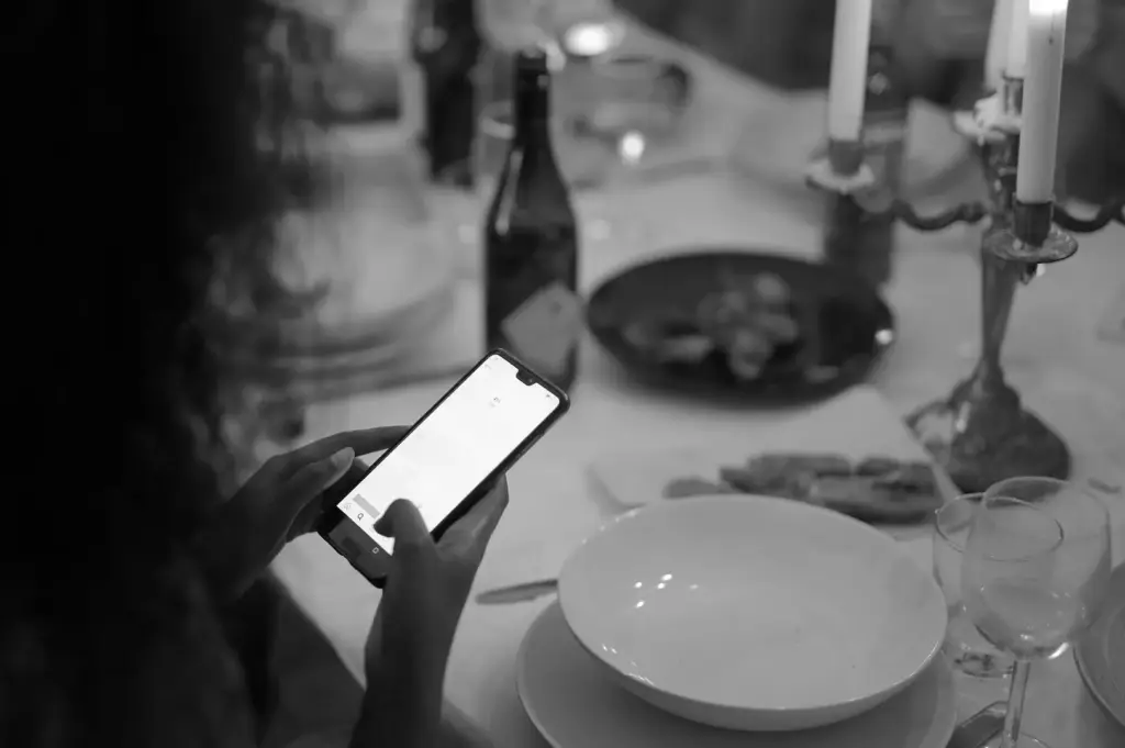 Customer using a smartphone at a restaurant table, highlighting digital dining technology.